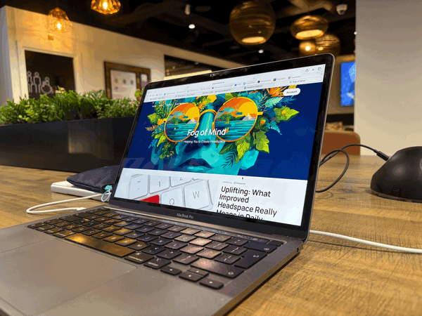 a MacBook displaying the Fog of Mind page, at the Santander Cafe, City of London